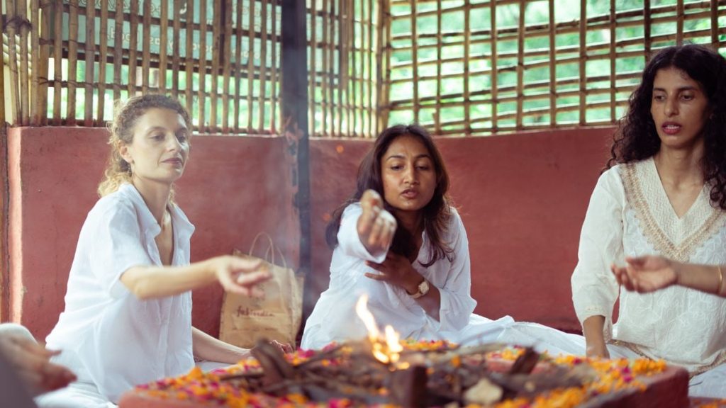 Women participating in a traditional spiritual ceremony in Rishikesh, India.